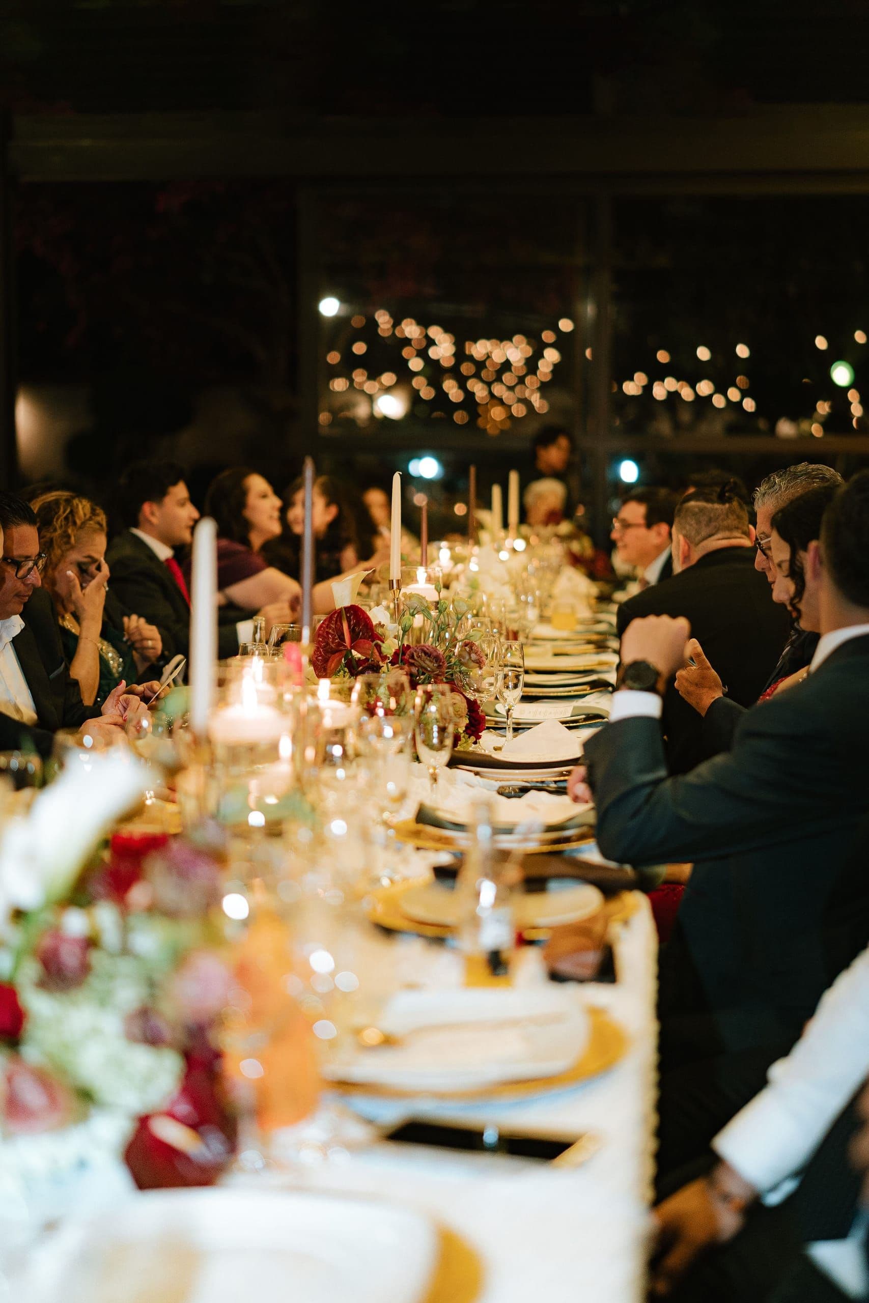 Mesa larga a la luz de las velas con invitados en una boda íntima en Puebla