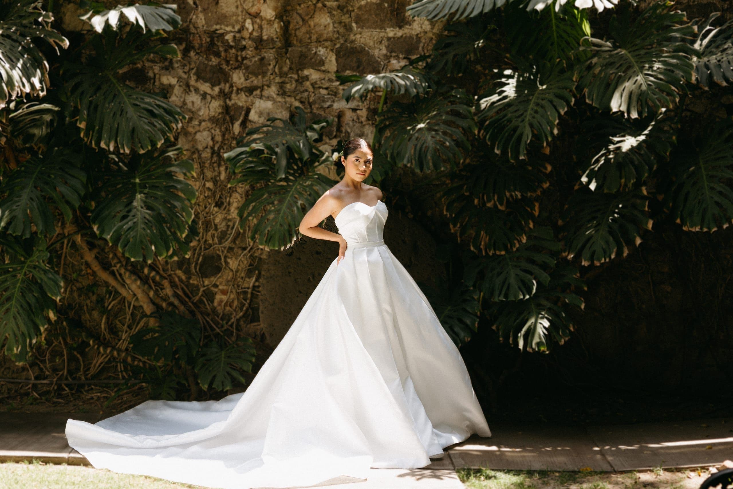 Novia con vestido de gala frente a la vegetación de un jardín, boda coordinada por Clhei
