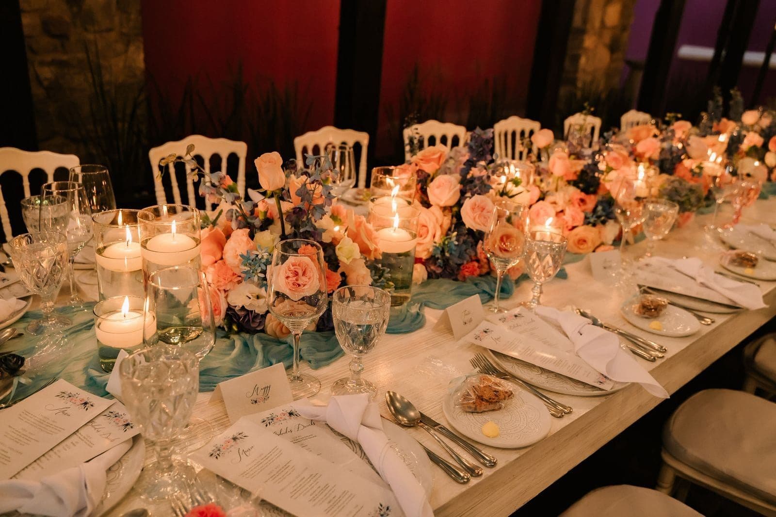 Mesa larga de banquete con rosas en tonos durazno y velas, por Clhei
