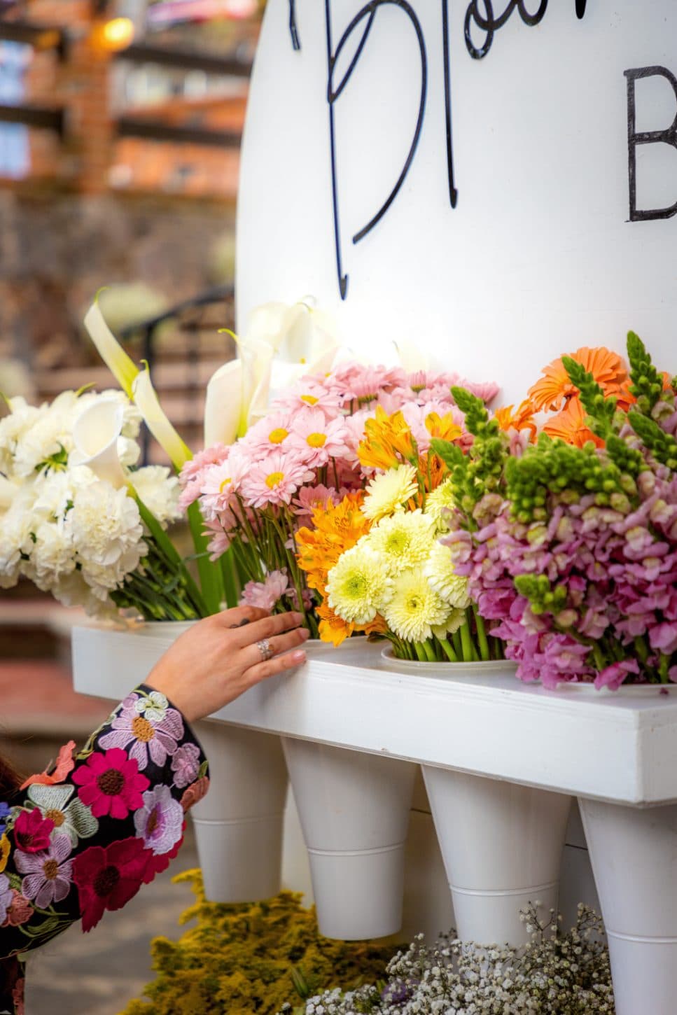 Our florist's hand arranging the flowers on the bar before the Flower Bar opens