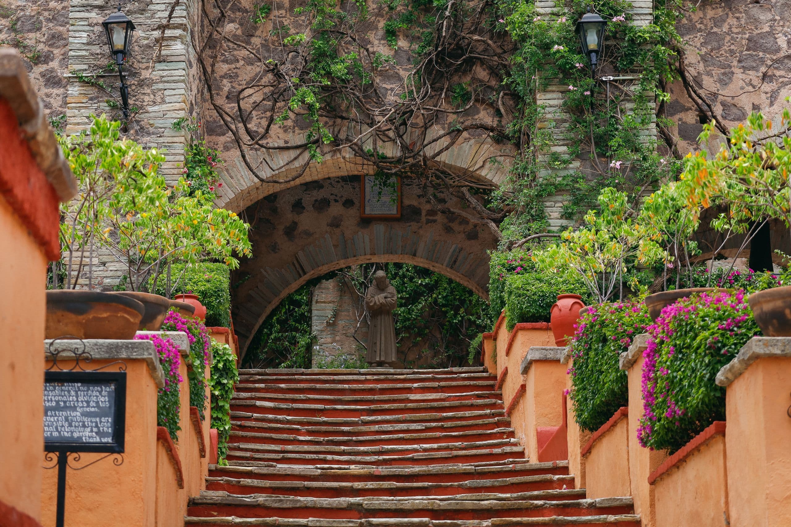 Stone archway and steps framed by bougainvillea in a Mexican hacienda garden