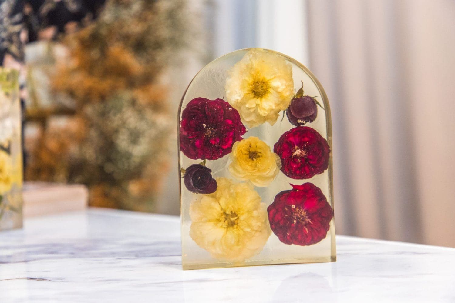 Pieza de resina en forma de arco con flores preservadas de un ramo de novia, por Eternals Clhei