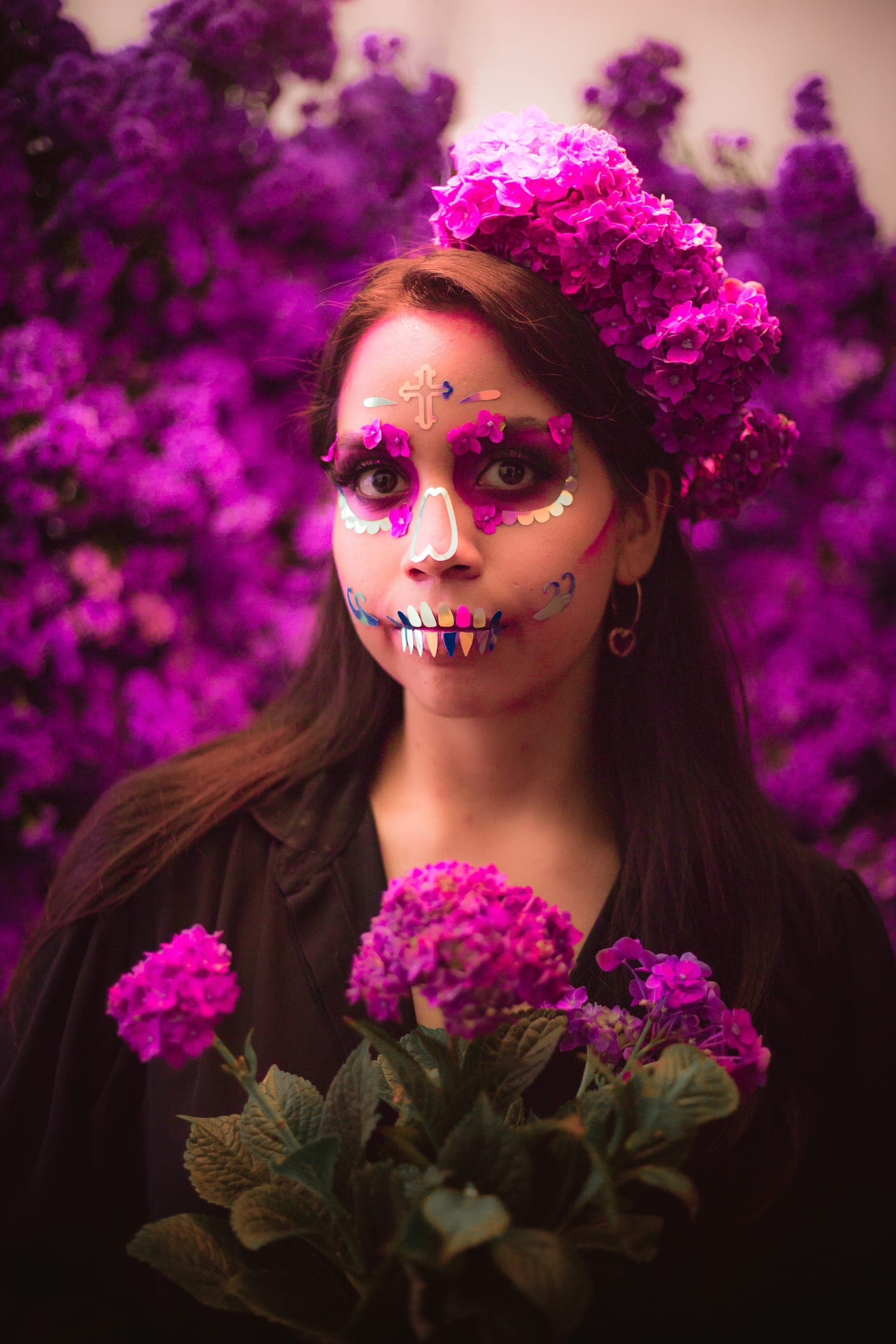 Retrato de catrina con maquillaje tradicional y buqué de hortensias rosas