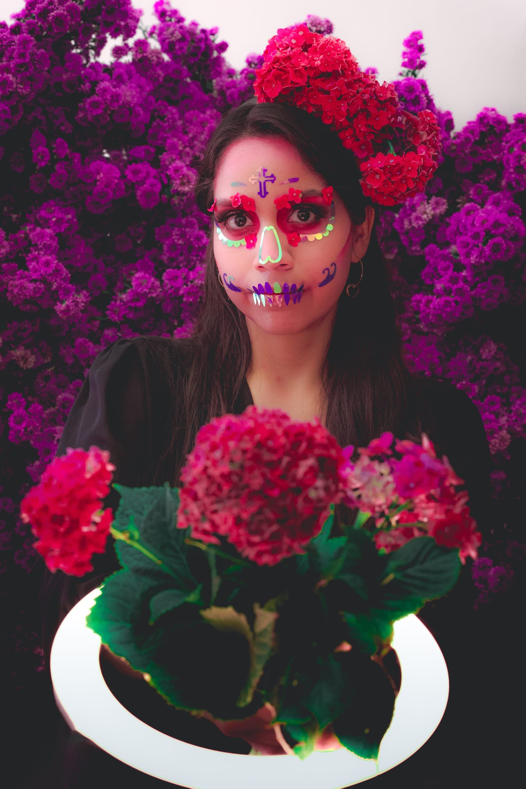 Catrina con hortensias rojas iluminada con aro de luz