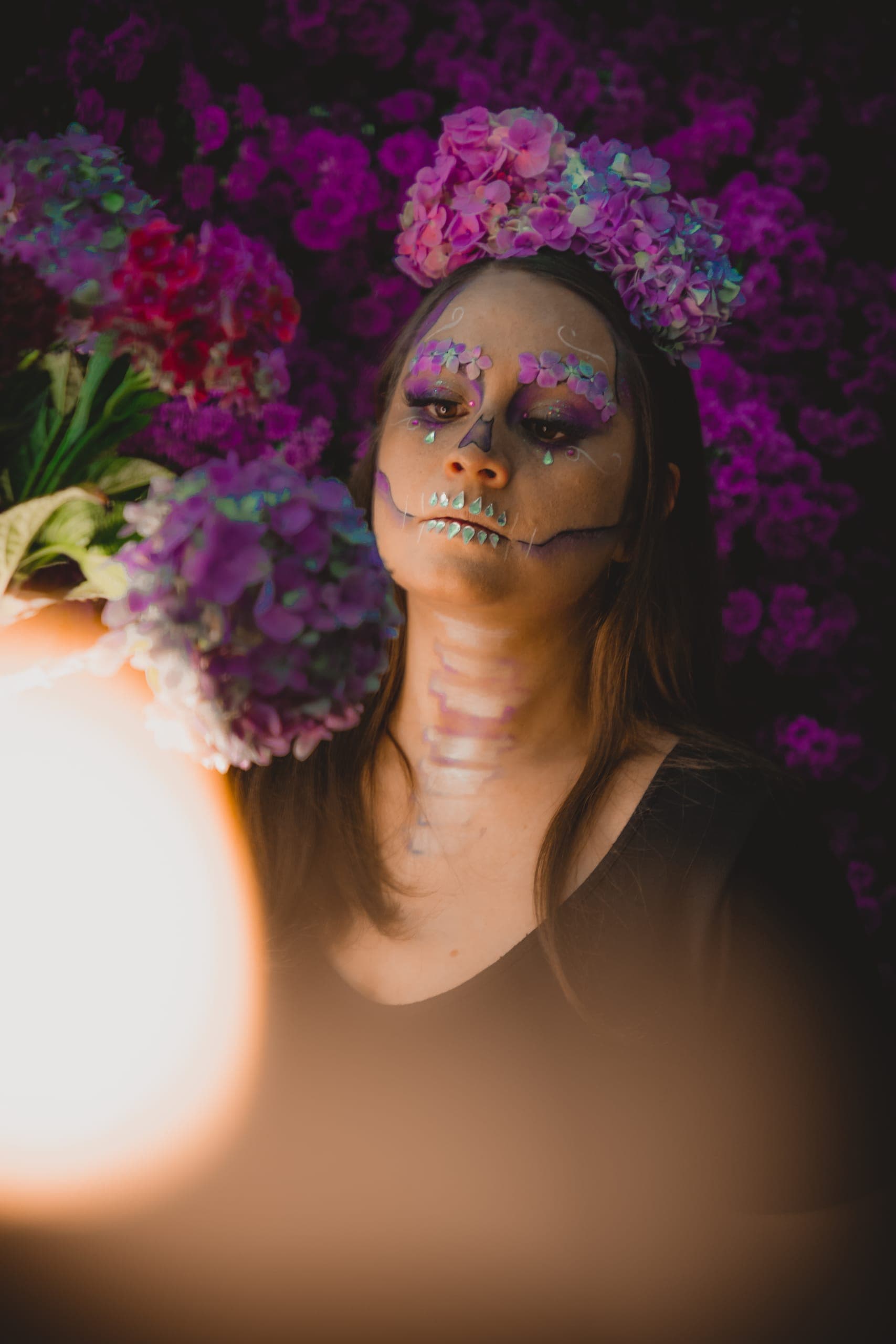 Retrato de catrina con corona floral entre luces cálidas