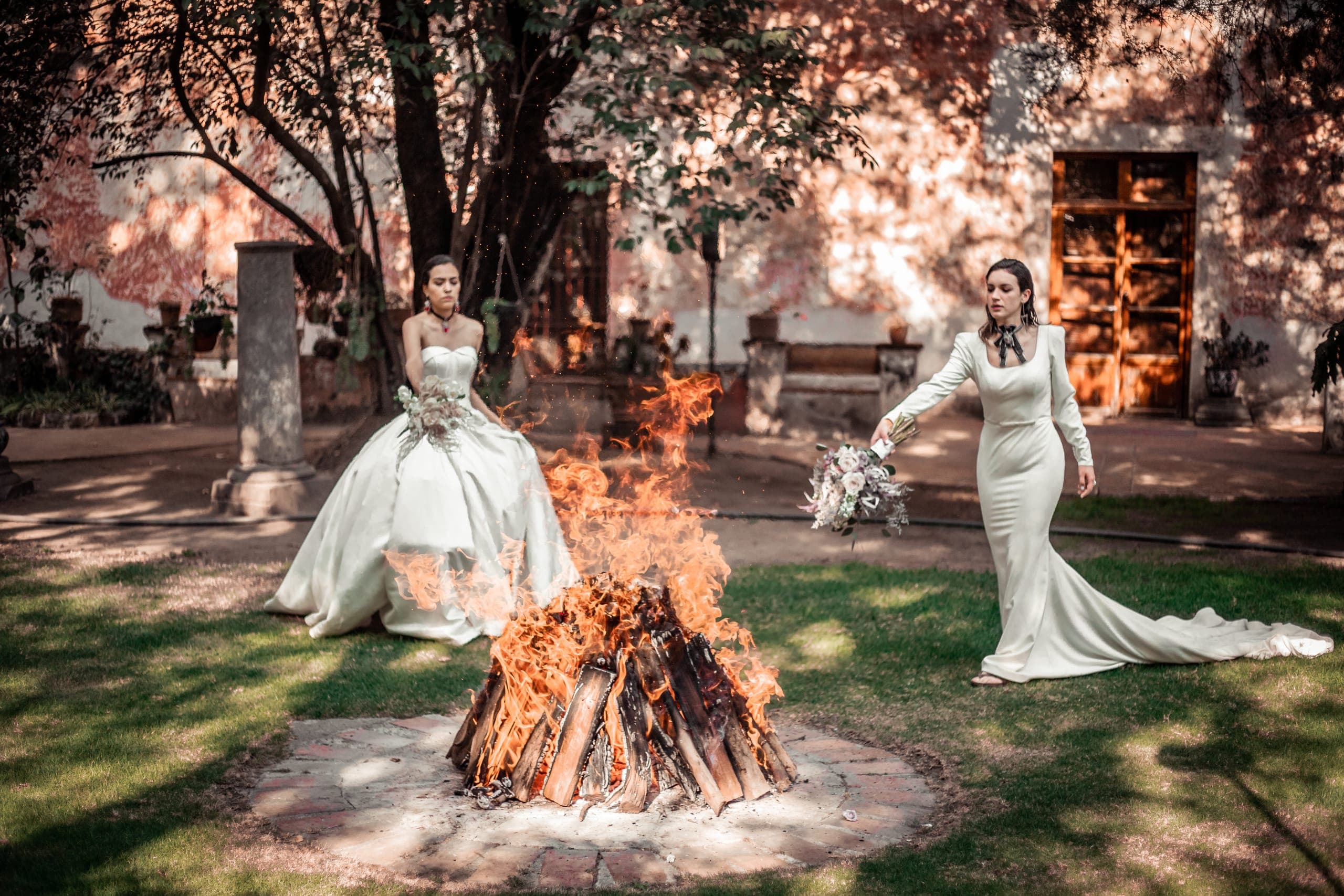 Dos novias junto a la fogata en el jardín al atardecer