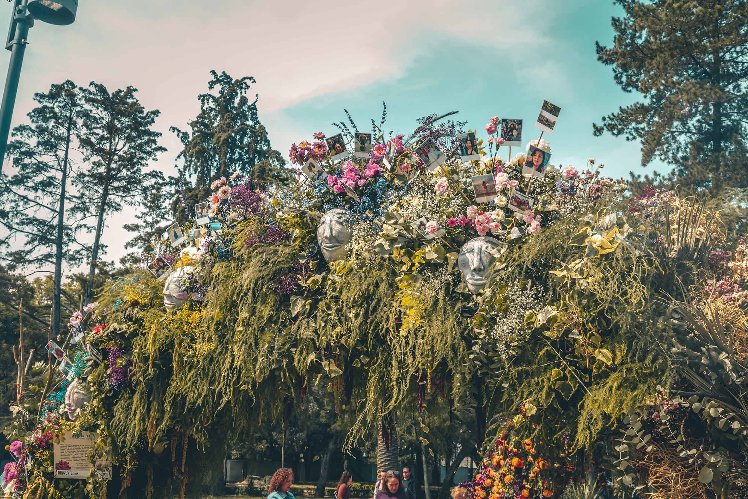 La instalación floral contra el cielo, con polaroids entre las flores