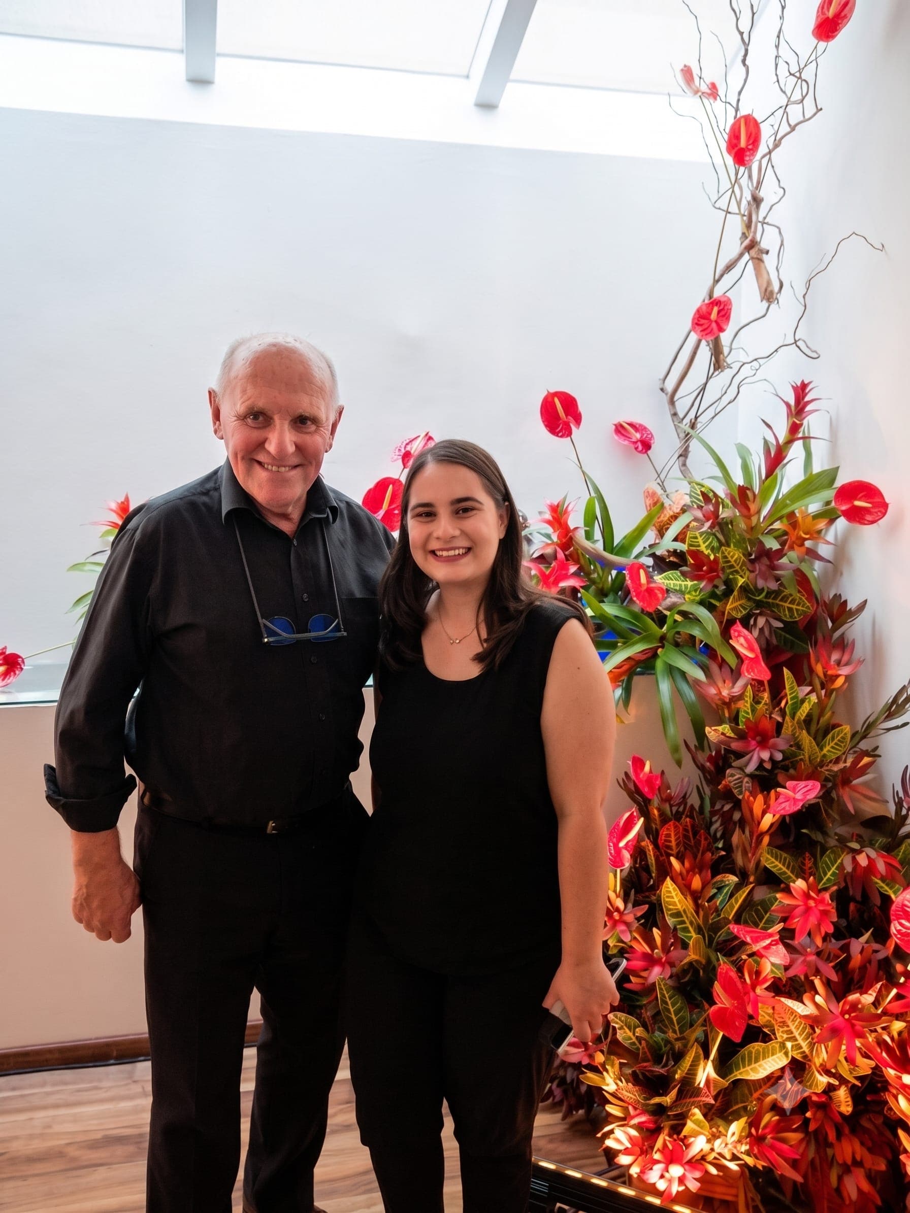 Tania con Jon Wheatley, vicepresidente de la Royal Horticultural Society y juez de FYJA, junto a un arreglo de anturios y bromelias