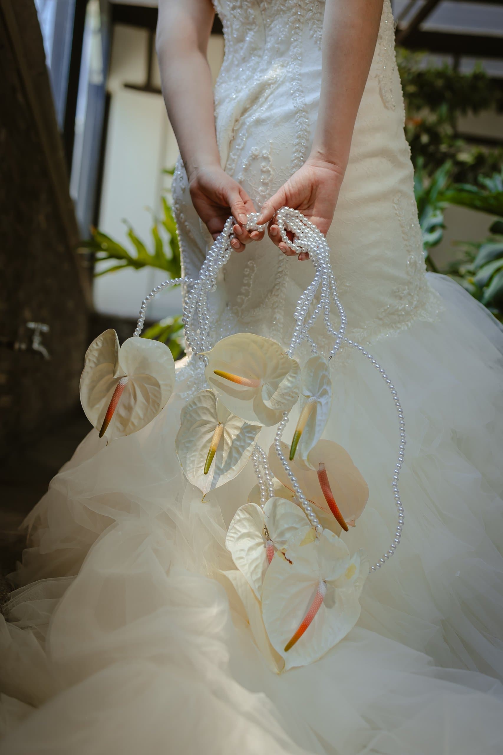 Ramo de anturios blancos con asa de perlas sobre vestido de tul