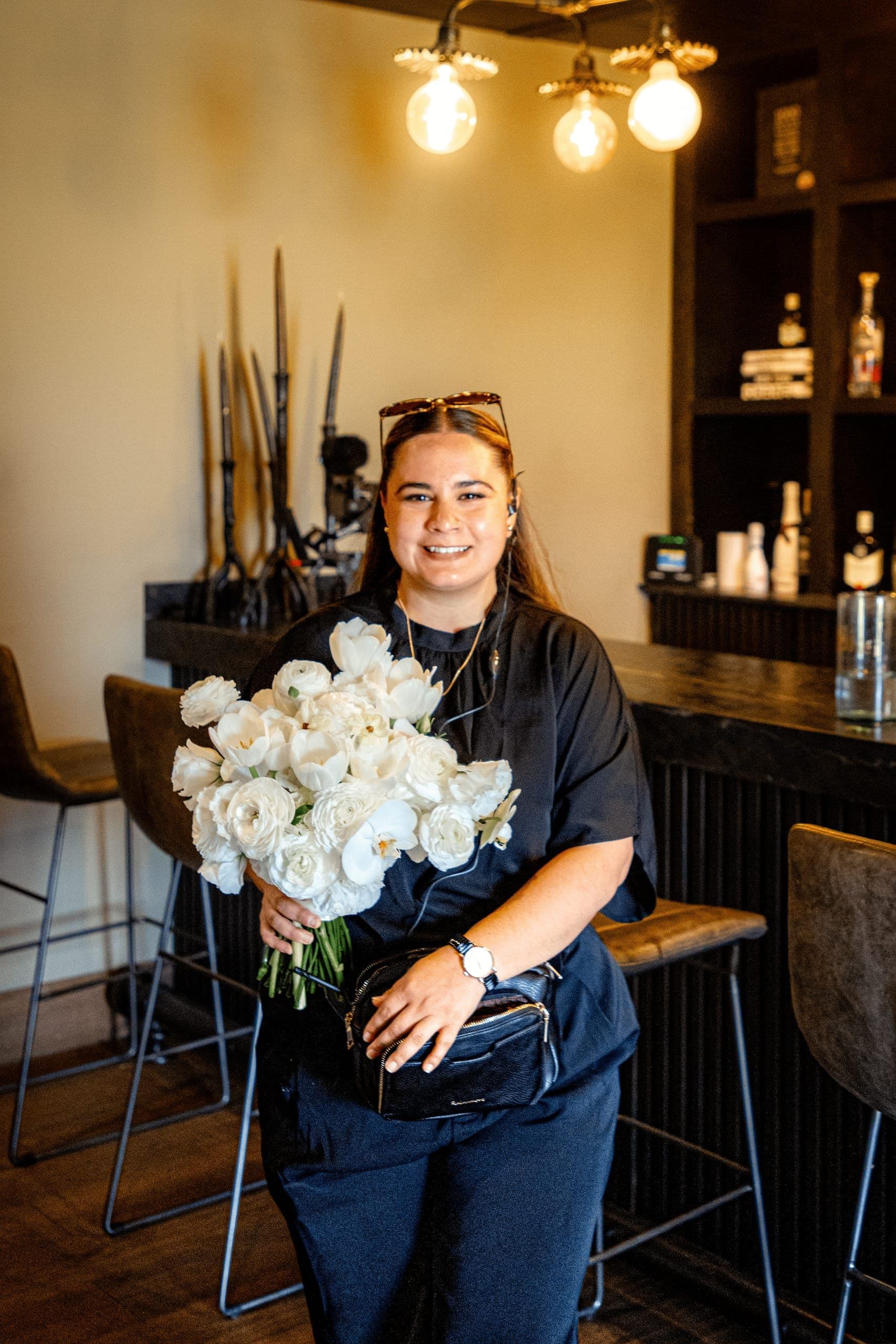 Integrante del equipo Clhei con un ramo de rosas blancas en el taller